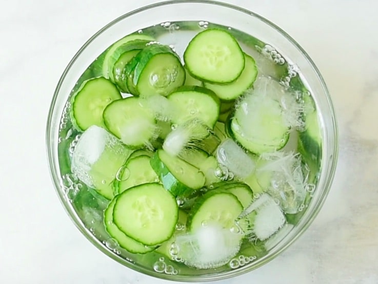 Cucumber slices in a bowl of ice water