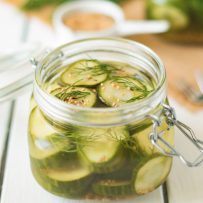 A poptop lid jar filled with dill pickle chips