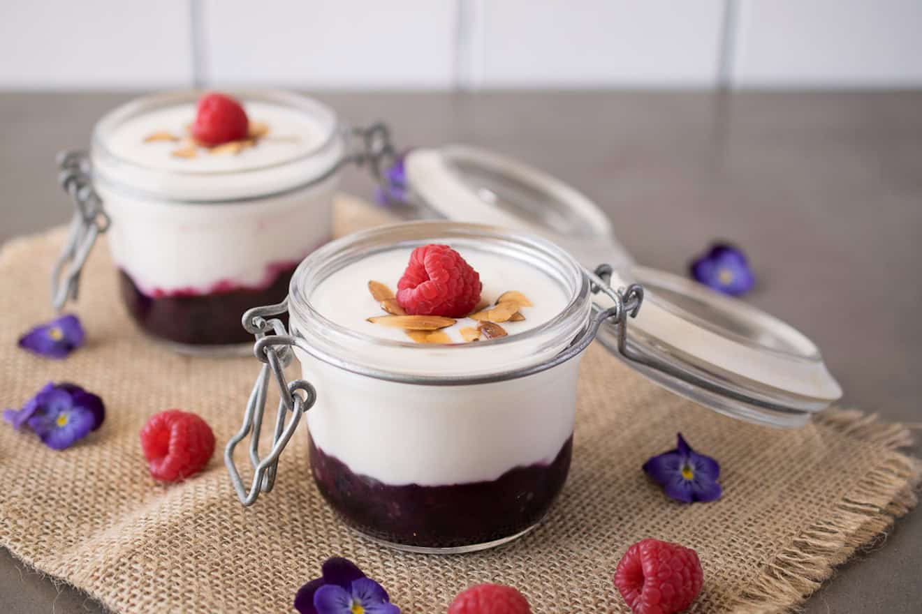 A glass jar filled with yogurt and fruit