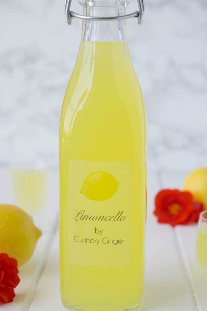 A large bottle filled with limoncello with a custom label that reads Limoncello by Culinary Ginger