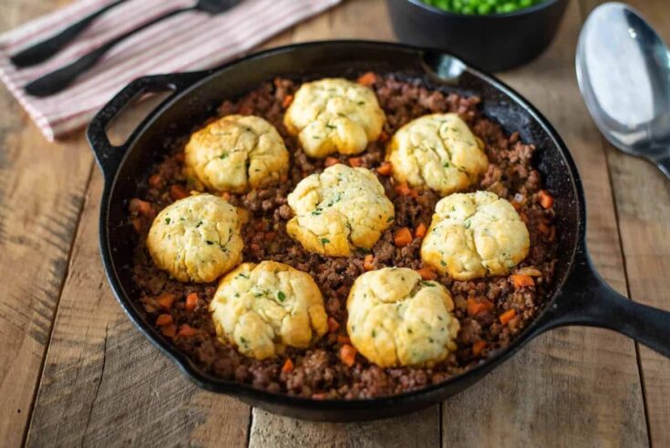 A pan of minced beef and carrots topped with crispy dumplings