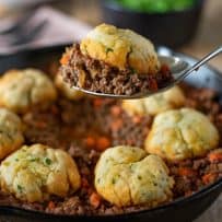 A spoon full of minced beef and dumplings