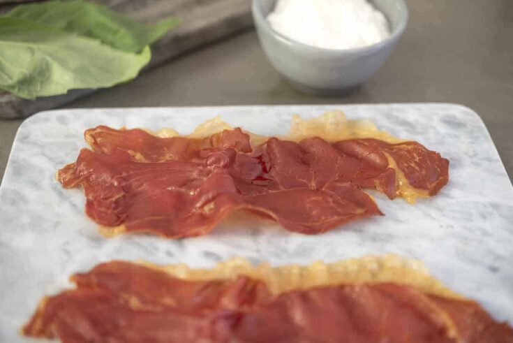 A closeup of a slice of prosciutto