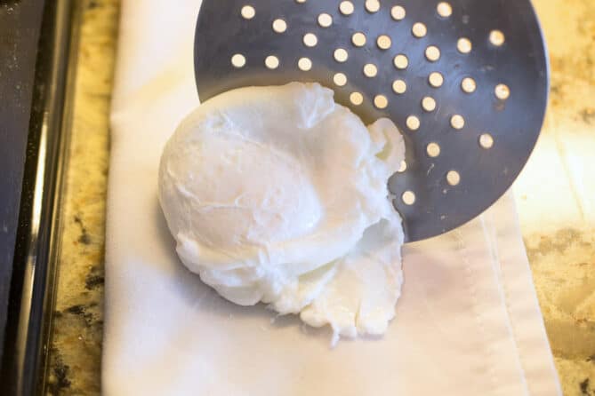 Placing a poached egg onto a paper towel