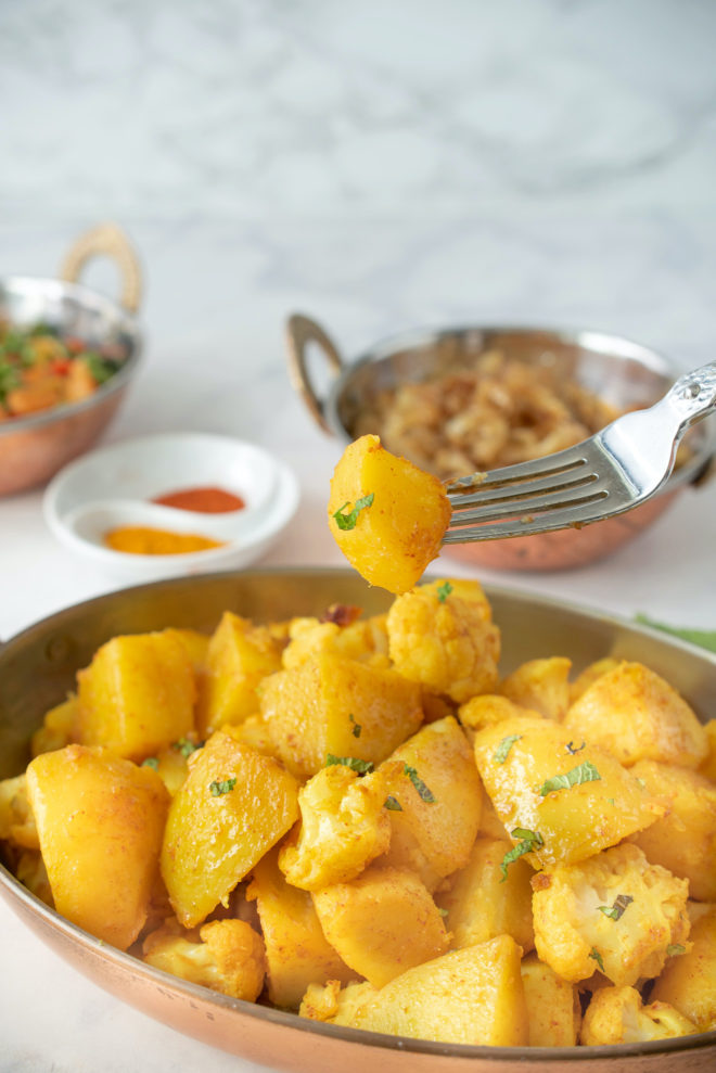 An Indian spiced potato wedge on a fork