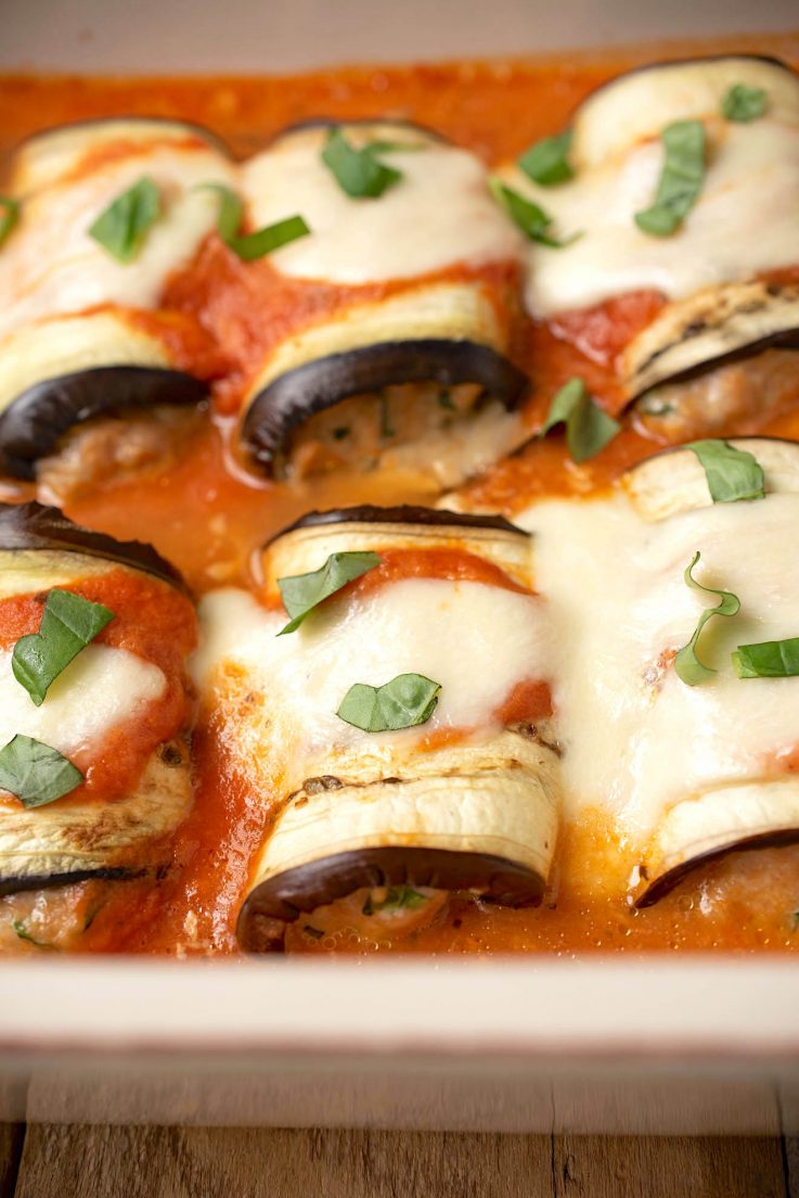 Eggplant rolls lined up in a casserole dish