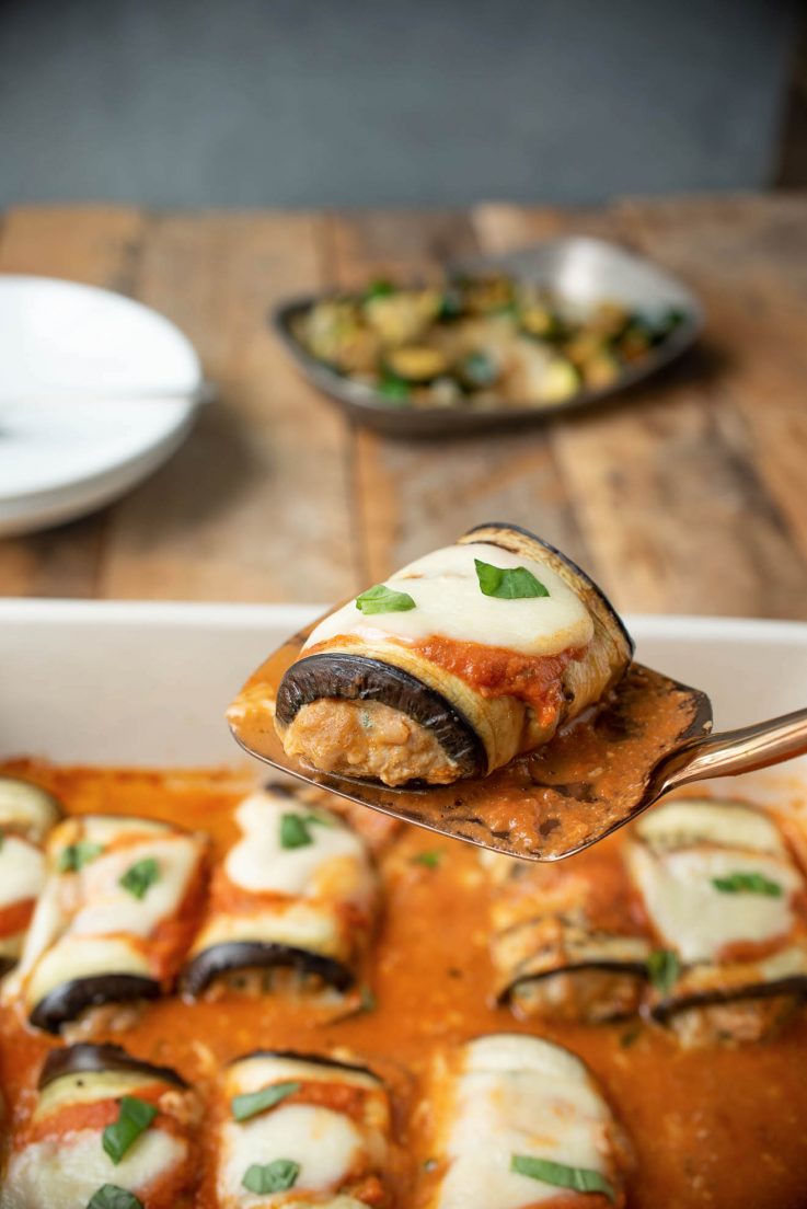 An eggplant roll filled with Italian sausage on a spatula
