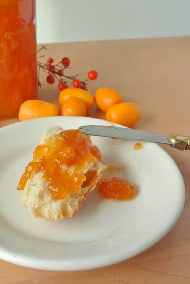 Kumquat marmalade spread onto bread on a plate