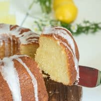 Lifting a slice of limoncello pound cake from a whole bundt cake