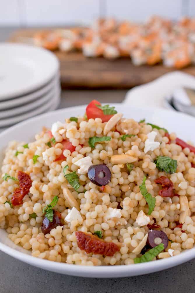 A closeup of pear couscous with olives, mint and sun-dried tomatoes