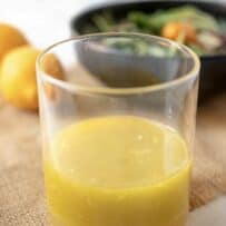 A glass jar of bright yellow Meyer lemon dressing and marinade