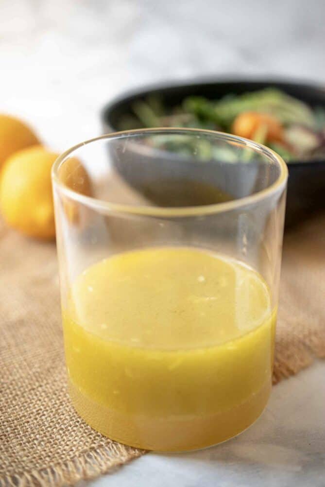 A glass jar of bright yellow Meyer lemon dressing and marinade