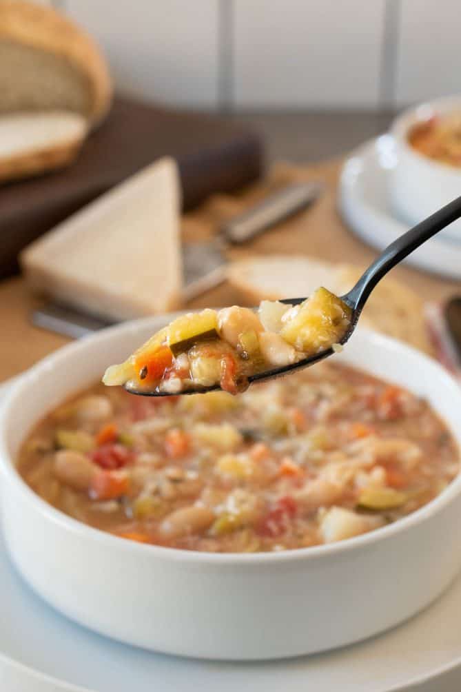 A spoonful of vegetables from minestrone soup