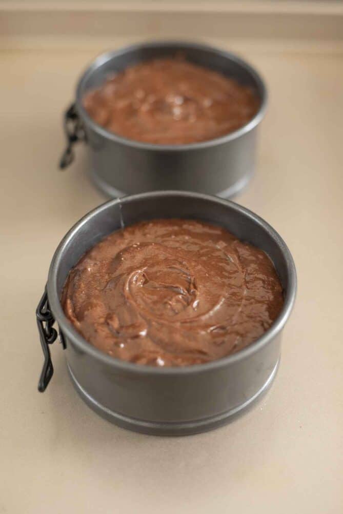 2 mini cake tins filled with chocolate cake batter