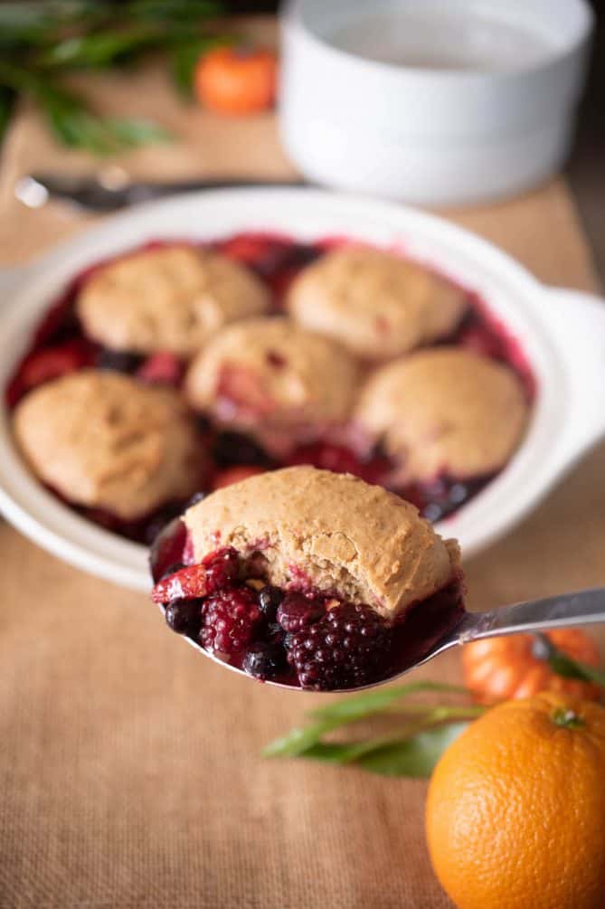 A ladle with a spoonful of berry cobbler