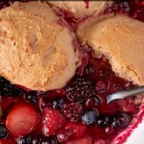 A closeup of the filling of berry fruit cobbler showing all the berries and pecan topping