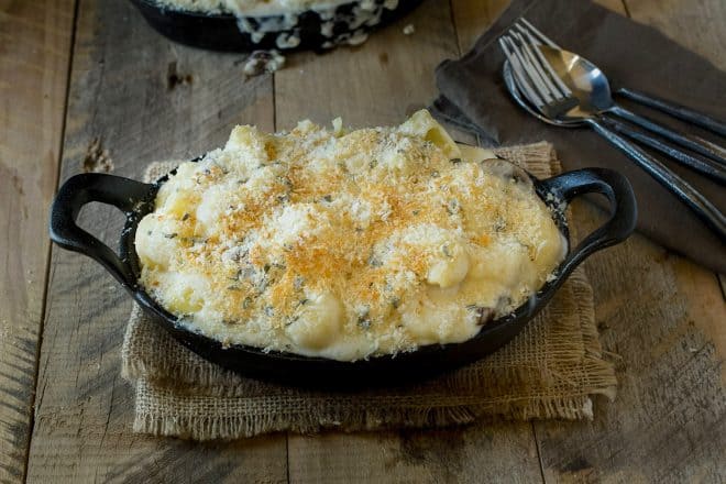 An oval dish full of mushroom sage mac and cheese