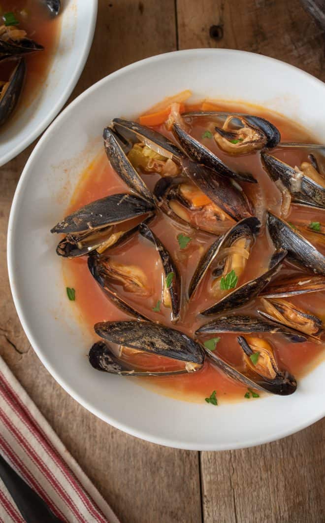 A closeup showing the mussels in their shells garnished with parsley
