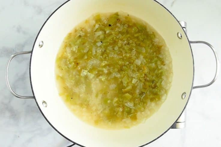 A pan of simmering green chile sauce