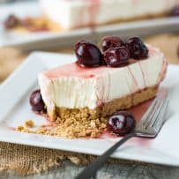 A slice of no bake cherry lemon cheesecake on a white plate with a fork