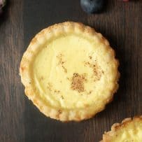 A closeup of a custard tart sprinkled with grated nutmeg