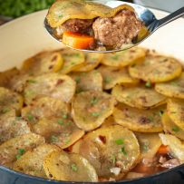 A spoonful of lamb, carrot and sliced potato