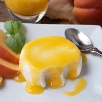 Panna cotta with some bites taken and peach sauce dripping