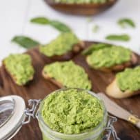 Pea and mint pesto in a jar with some on crostini in background