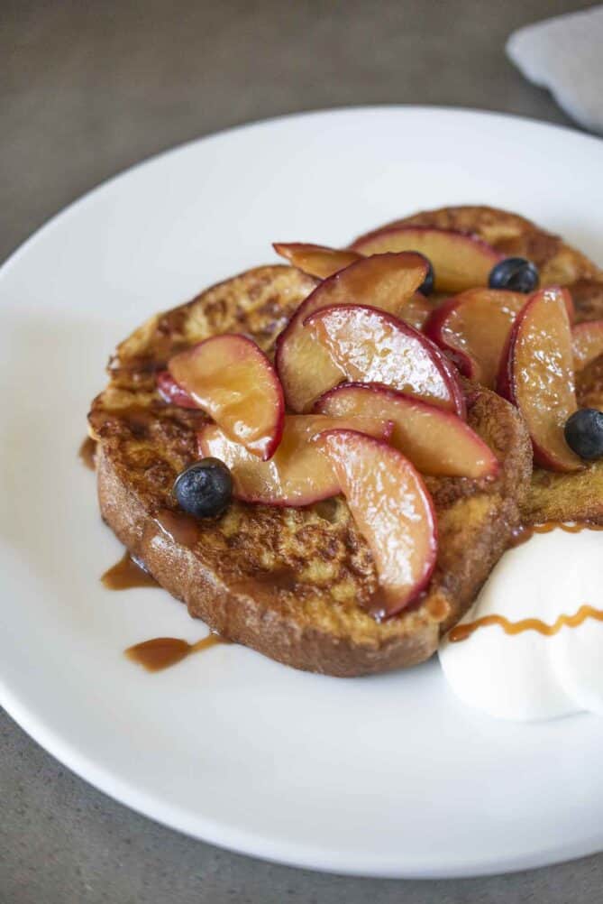 A closeup of sliced peaches glazed with butter and caramel sauce