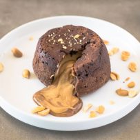 Creamy peanut butter running out from the inside of a chocolate lava cake