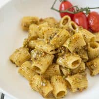 A nutty pistachio pesto served over pasta in a white bowl