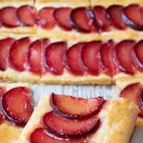 A closeup of a square of plum tart
