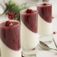 Pomegranate panna cotta decoratively presented in a glass half white and half red