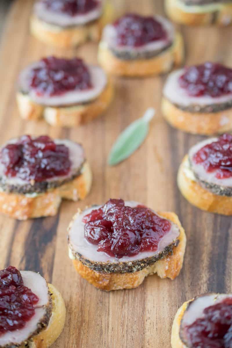 Pork and cranberry crostini. Tender roast pork tenderloin slices with sweet cranberry sauce, sage mustard on crispy baguette slices.