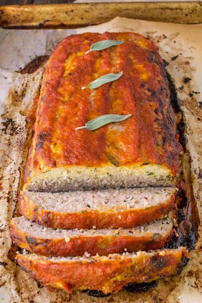 Pork apple and sage meatloaf right out of the oven with fresh sage leaves