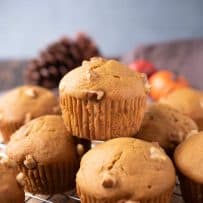 A pumpkin walnut muffin on top of other muffins