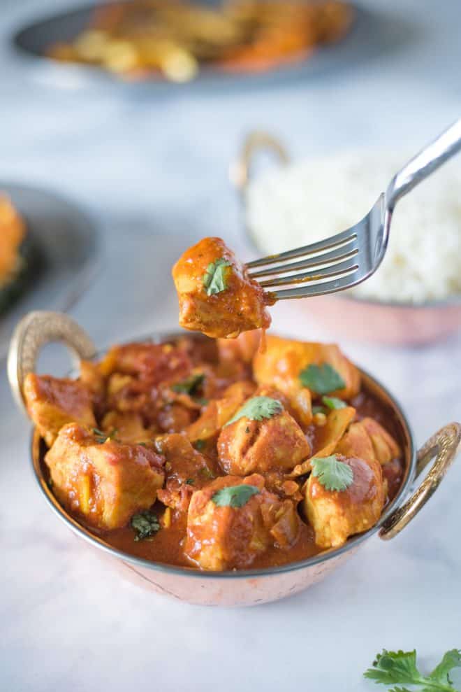 A piece of chicken madras on a fork