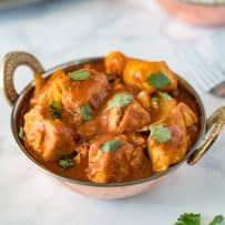 Chicken madras served in an Indian Karahi topped with fresh cilantro