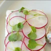 Pretty slices of radish top a slice of bread spread with herb butter