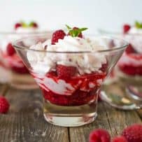 A closeup of the layers of cream and raspberries in a raspberry fruit fool