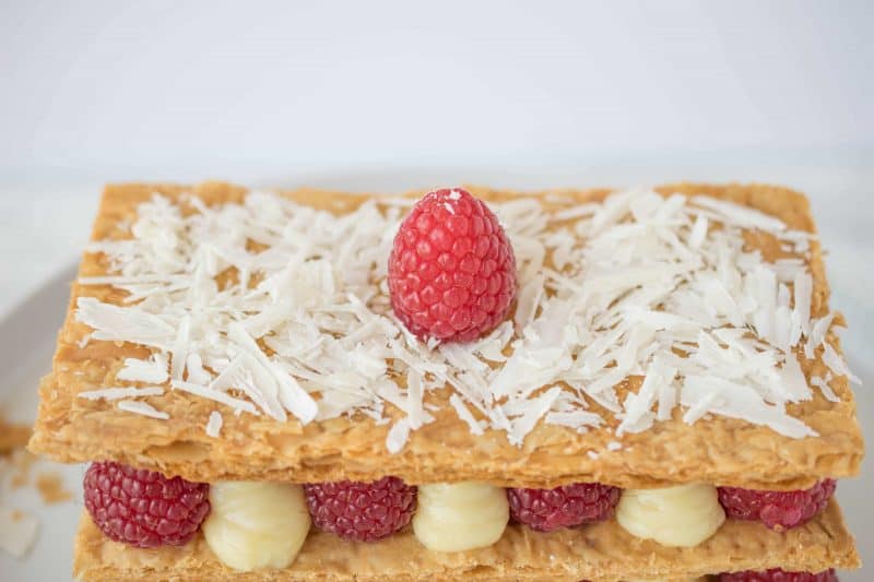 A closeup of the top showing shaved white chocolate and a raspberry