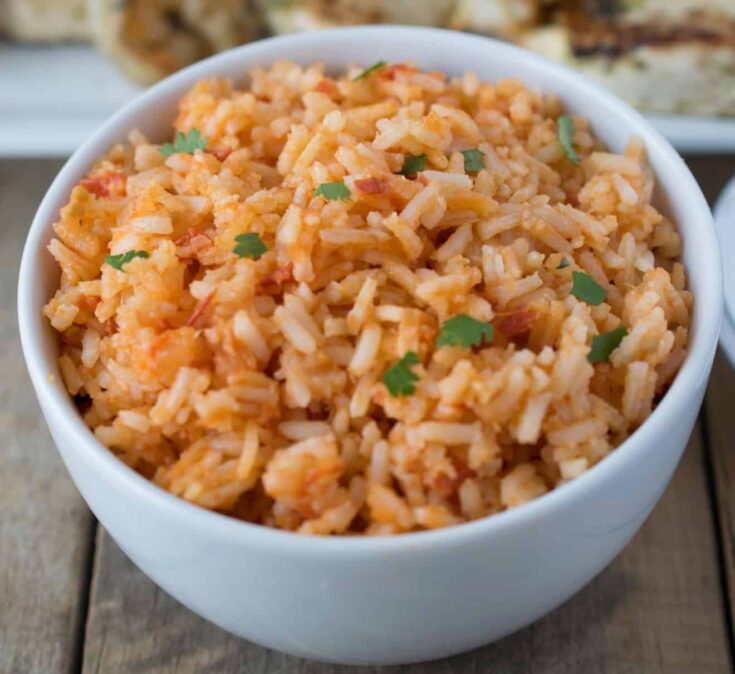 A closeup showing grains of rice colored with red tomatoes