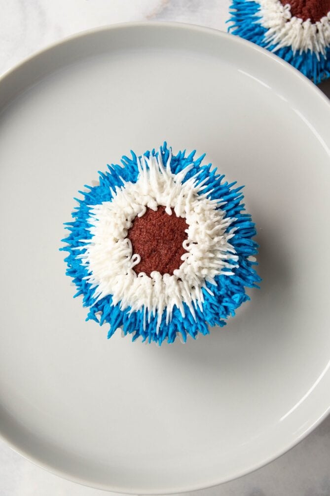 A cupcake frosted with white and blue