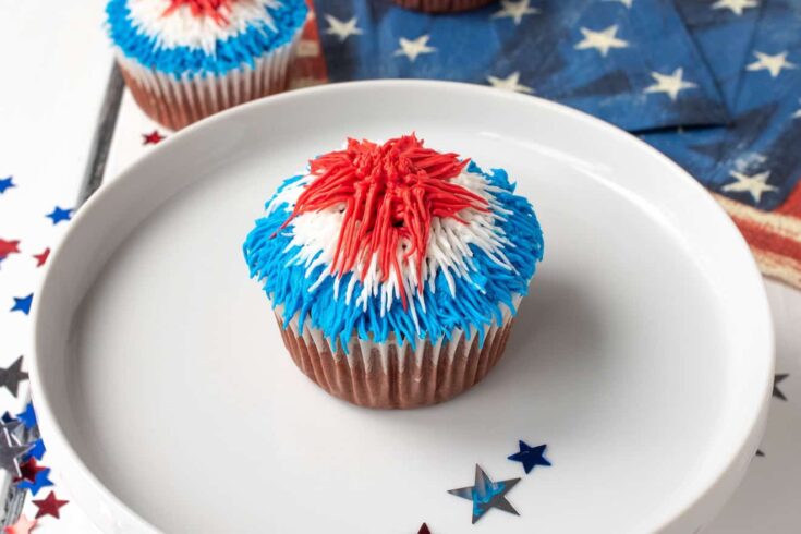 A closeup of a cupcake topped with red, white and blue frosting
