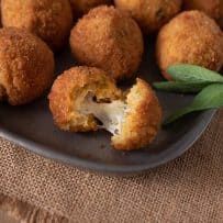 A risotto rice ball opened up to reveal the cheesy center