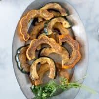 An oval plate of roasted acorn squash viewed from overhead