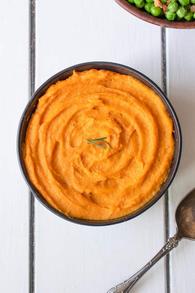 Vibrant orange carrot and parsnip pureed swirled in a bowl, viewed from overhead
