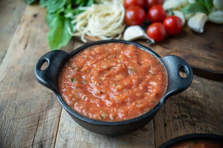 A black bowl filled with fresh tomato sauce