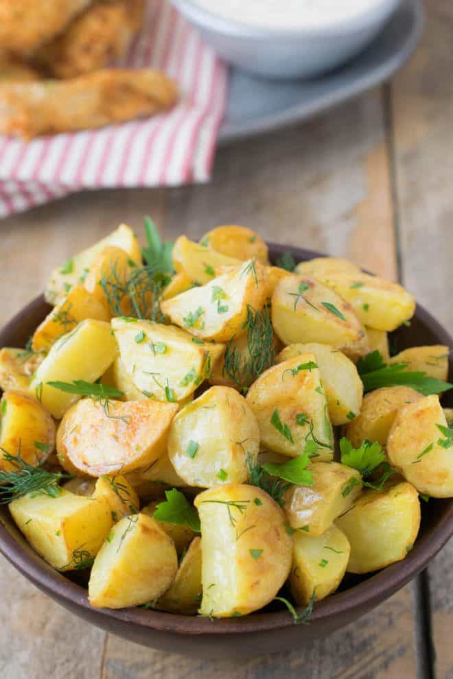 A closeup of the browned potatoes topped with fresh herbs