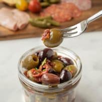 A green olive on a fork